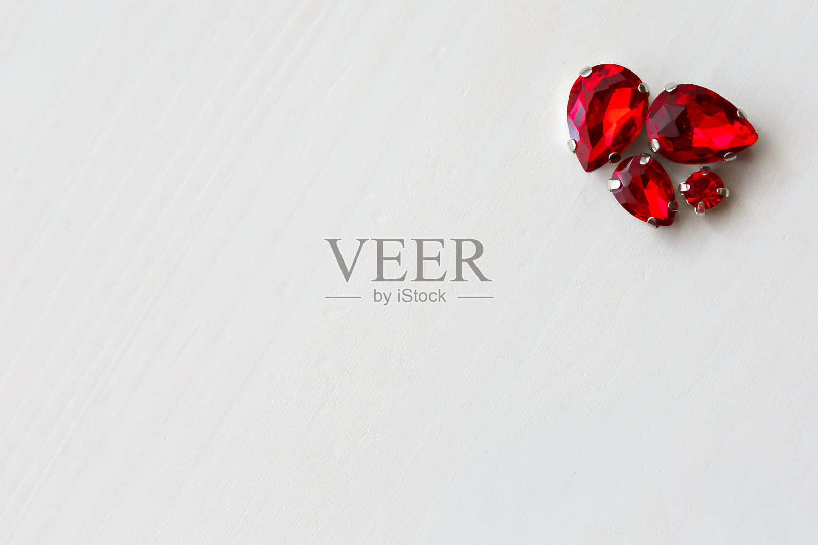 白色木质背景上的红色珠子照片摄影图片