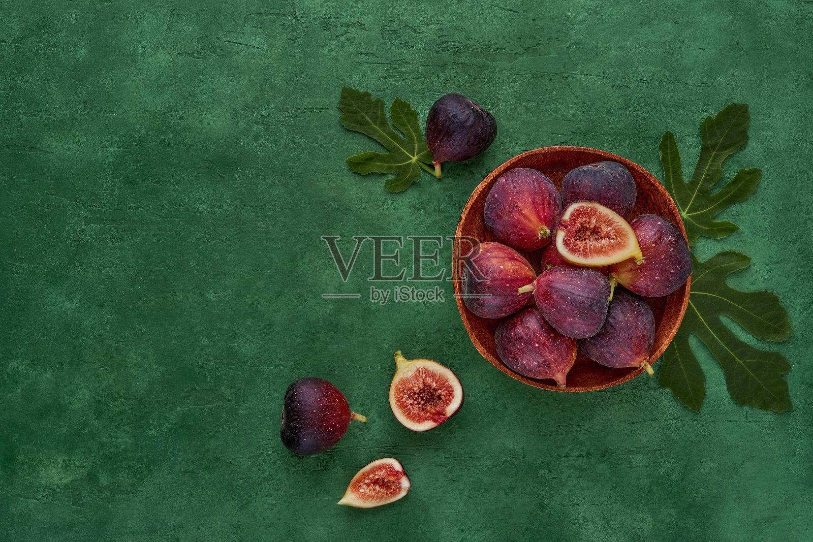 新鲜成熟的无花果放在木盘子里。顶部视图与复制空间照片摄影图片