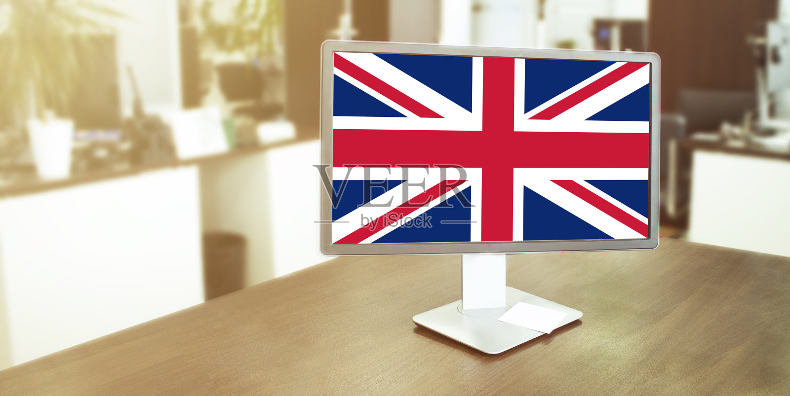 显示器在现代办公室，屏幕上有英国国旗照片摄影图片