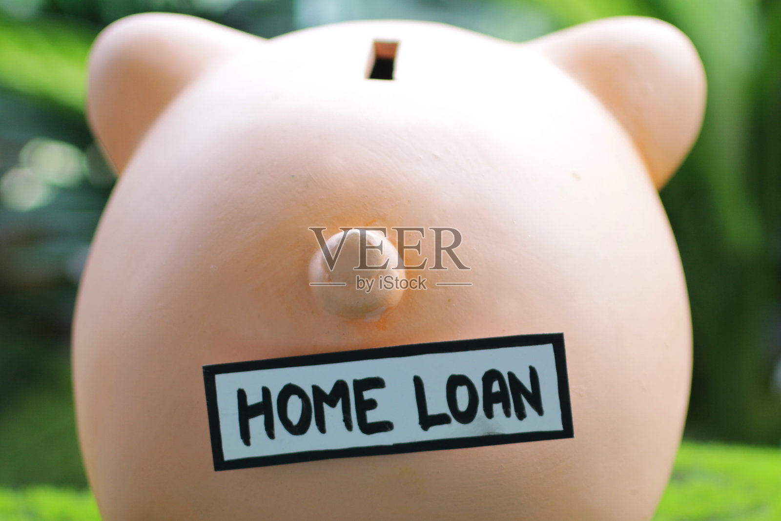 特写图像的小猪银行尾部与家庭贷款标签，插槽顶部，家庭财务和储蓄概念照片摄影图片