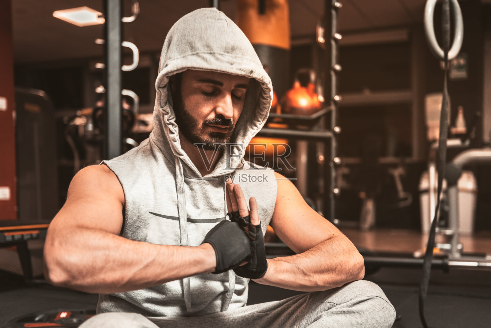 一名蓄着胡须的运动男子正在体育馆里以莲花姿势冥想。瑜伽的精神利益。照片摄影图片