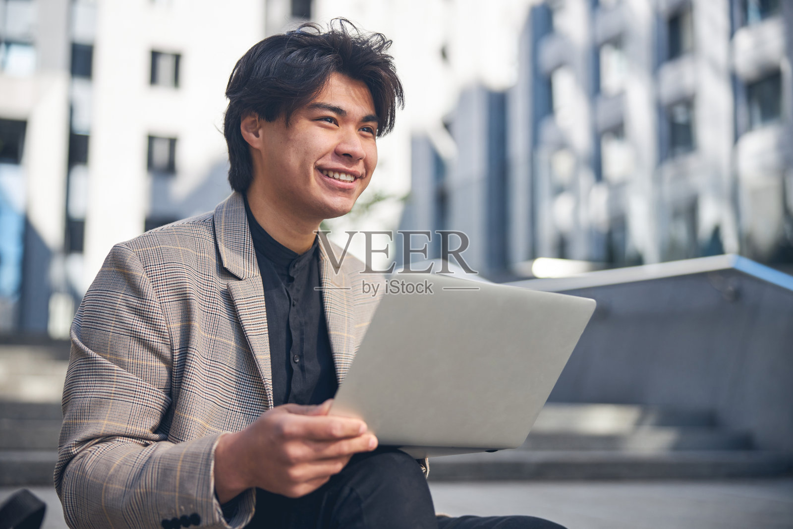 英俊的年轻人在街上用笔记本照片摄影图片