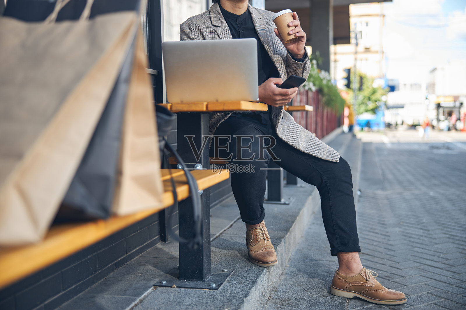 在户外咖啡厅喝咖啡和使用笔记本电脑的时尚男士照片摄影图片
