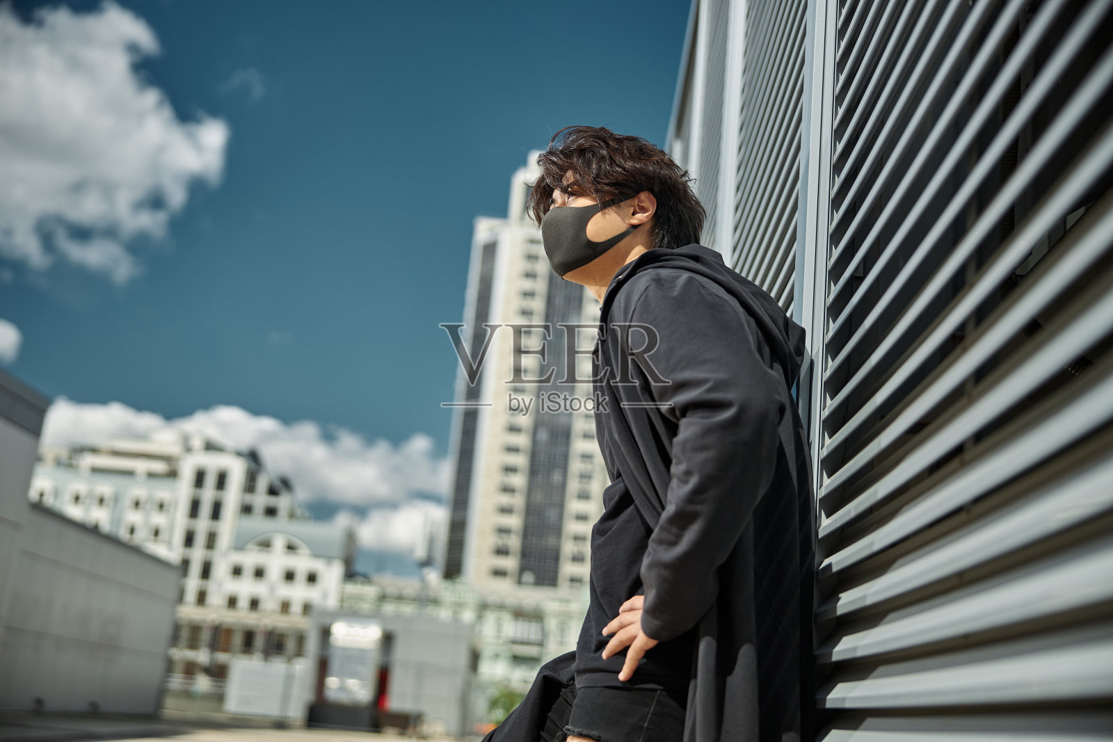 英俊的年轻人戴着防护面具站在街上照片摄影图片