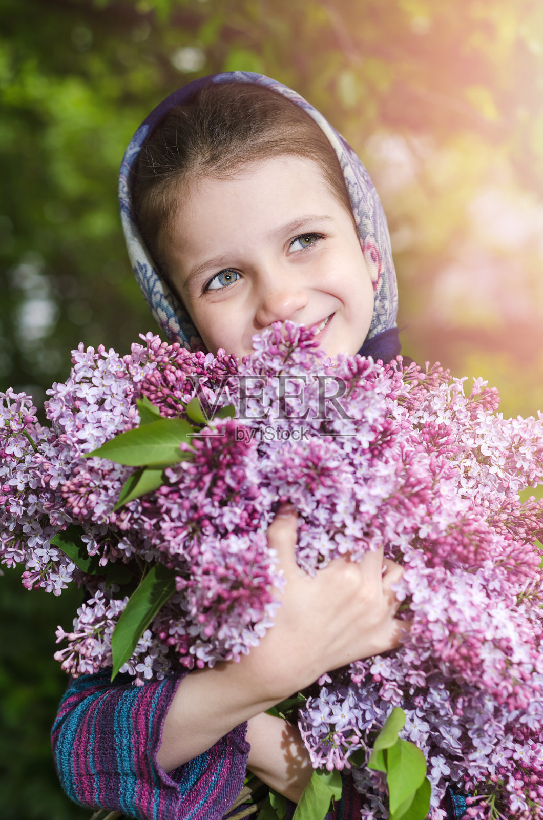 一个手里拿着一束紫丁香的小女孩照片摄影图片
