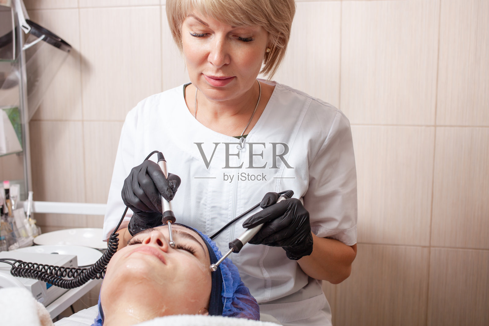 美容师在美容院里做微电流手术。照片摄影图片