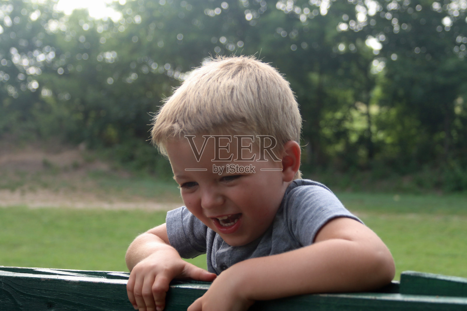 年轻的金发白种人男孩，在公园外面照片摄影图片