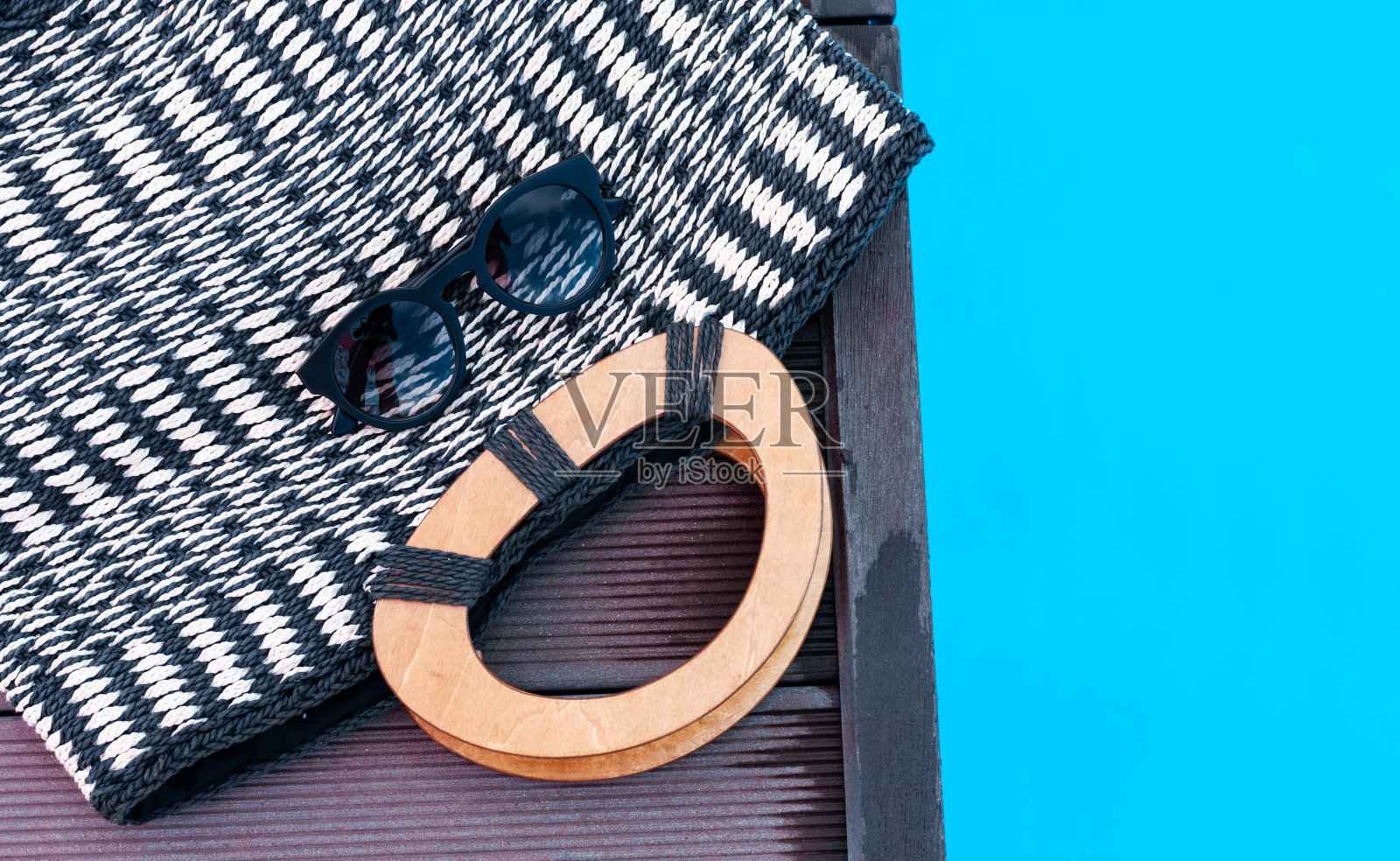 复古夏季柳条草编沙滩包，太阳眼镜靠近游泳池，热带背景照片摄影图片