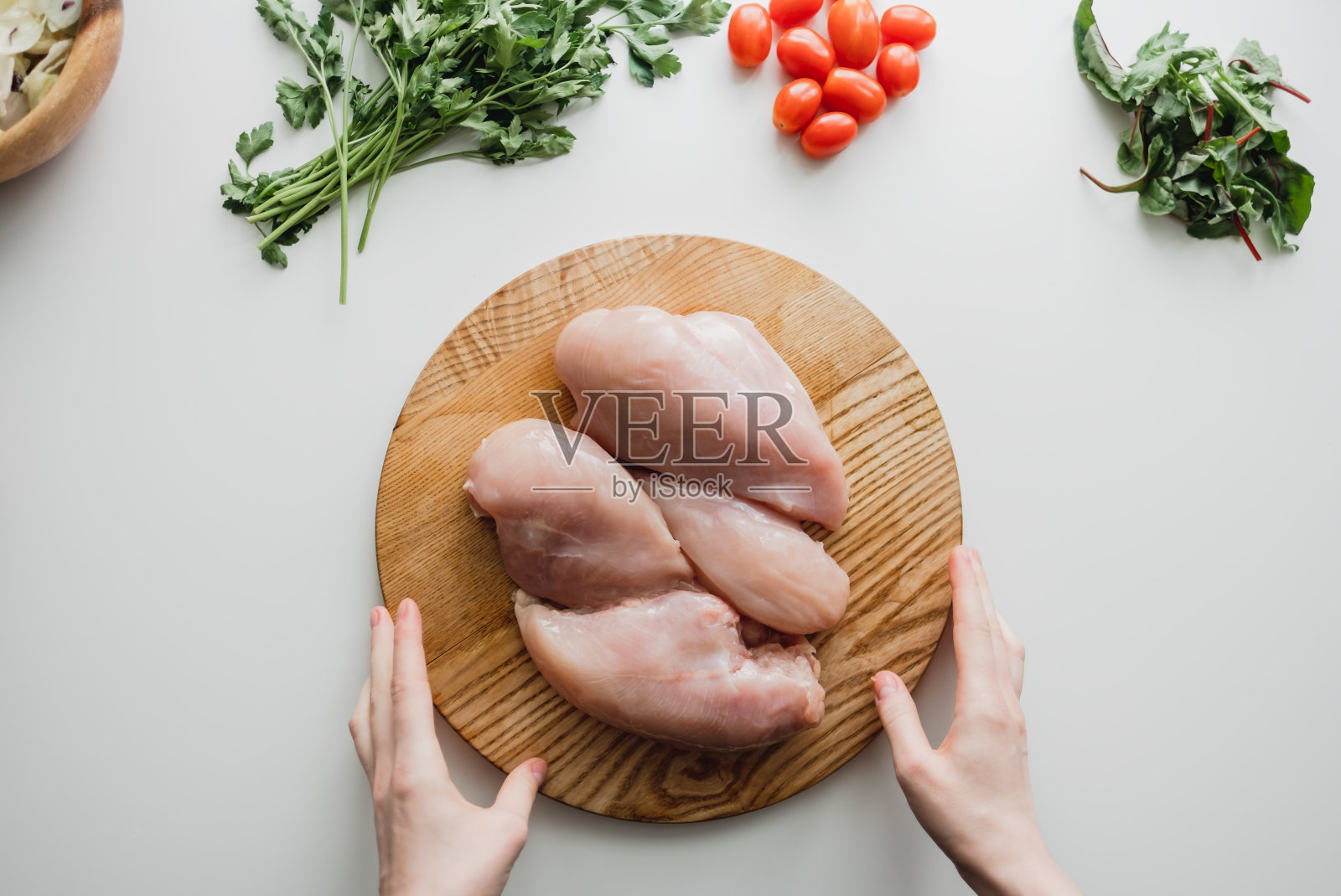 鸡柳放在木板上，配上香草，白色背景。照片摄影图片