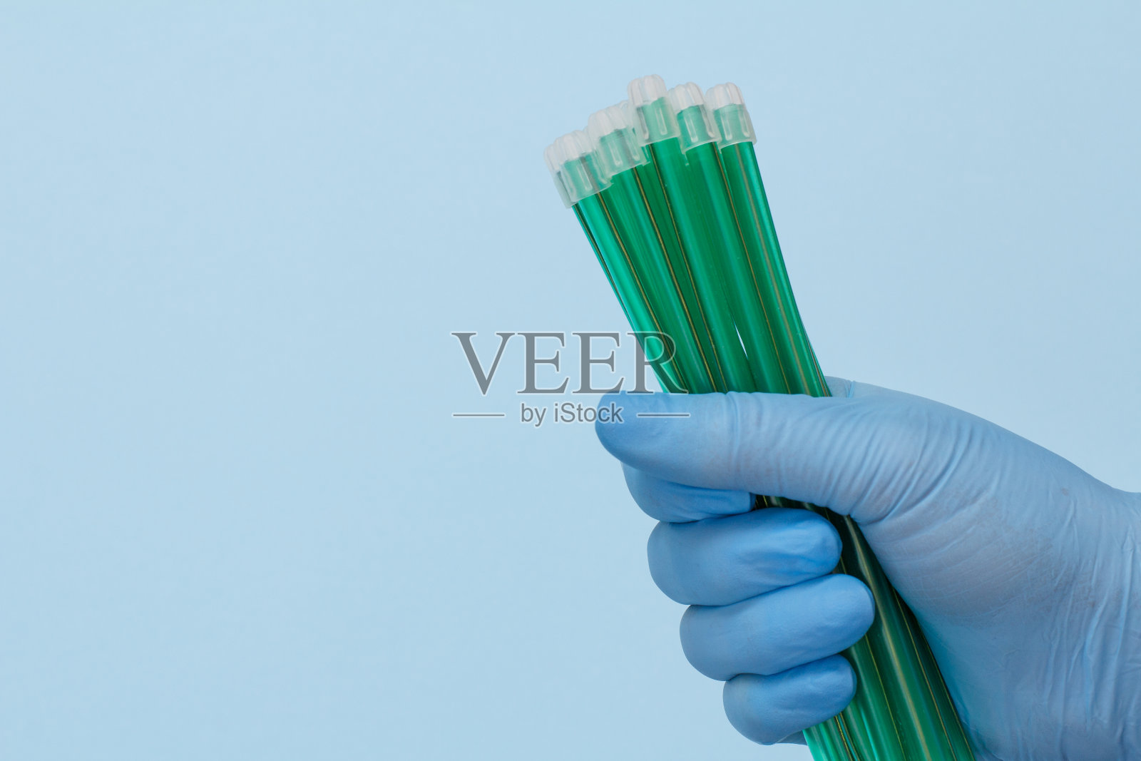 牙医的手与唾液喷射器手套。照片摄影图片