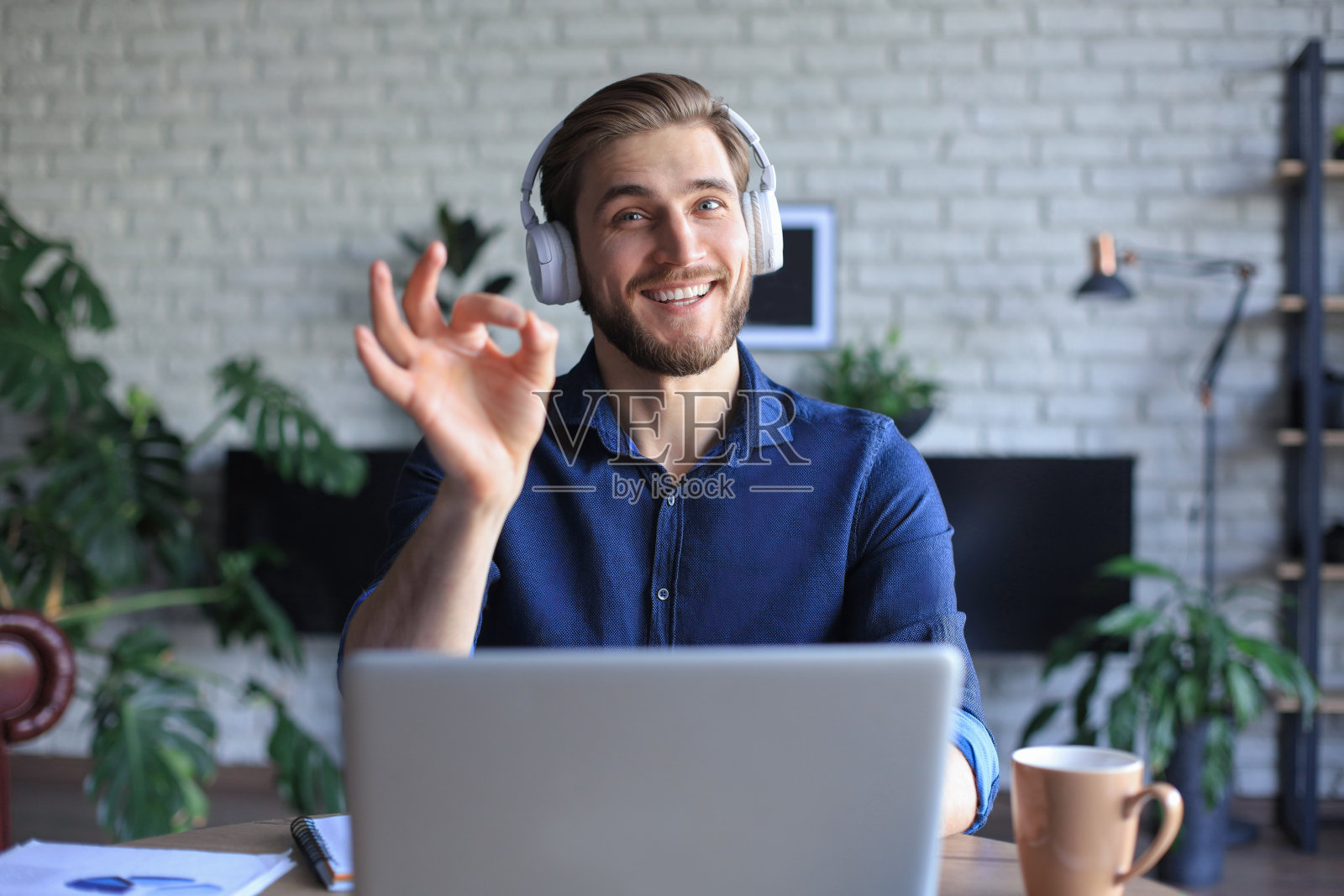 在自我隔离和隔离期间，商人通过视频电话与同事进行在线通报。流感流行和covid-19。照片摄影图片