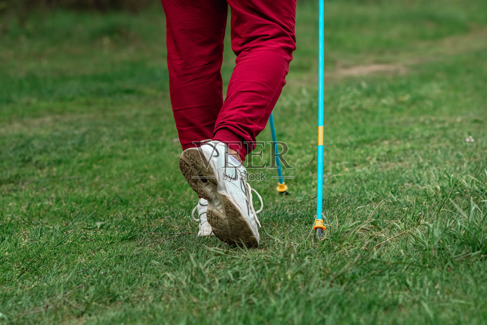 北欧人走路，棍棒，腿特写。健康的生活方式，有氧运动的概念。Copyspace。照片摄影图片