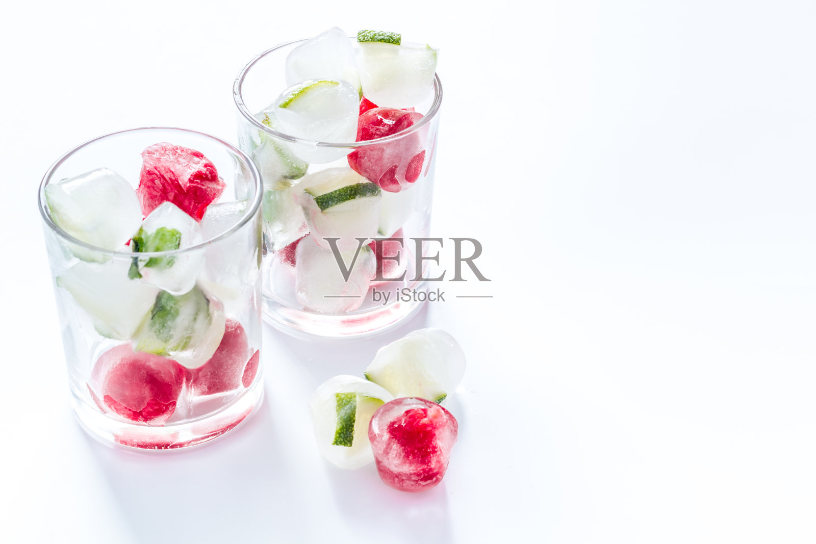 鸡尾酒杯加冰块浆果放在白色的桌子上照片摄影图片