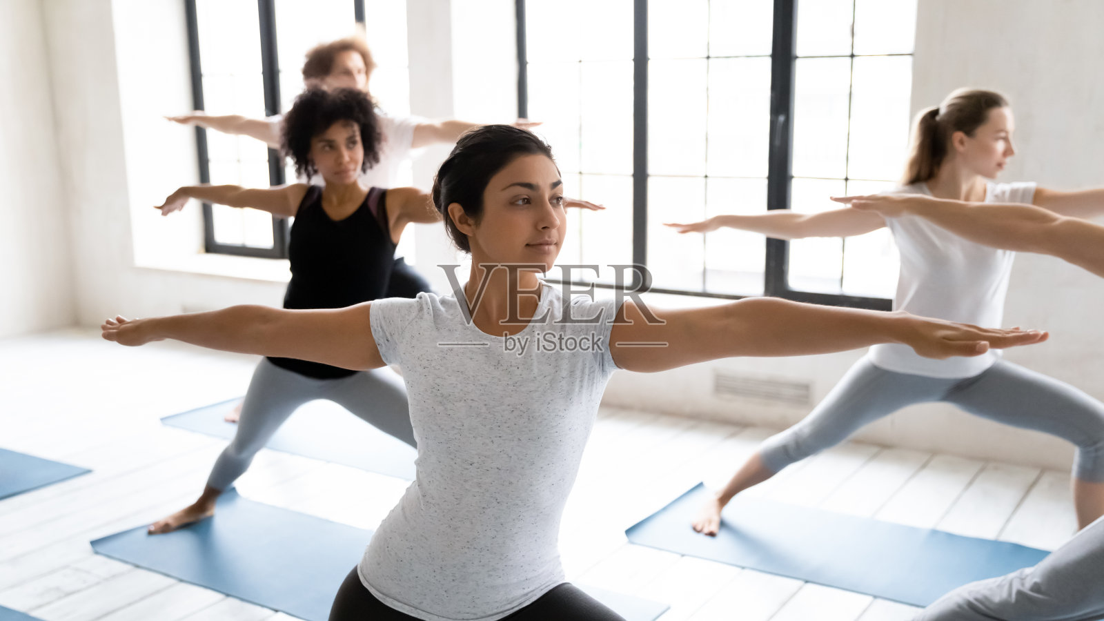 年轻健康的印度民族妇女站在virabhadrasana第二位置。照片摄影图片