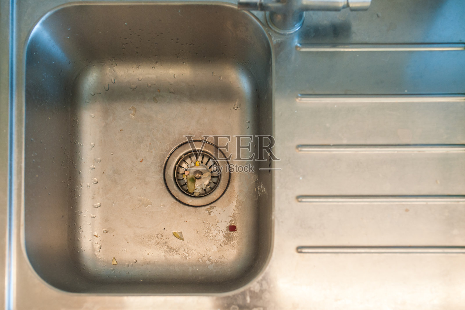 厨房水槽堵塞。有剩菜的肮脏金属水槽。照片摄影图片