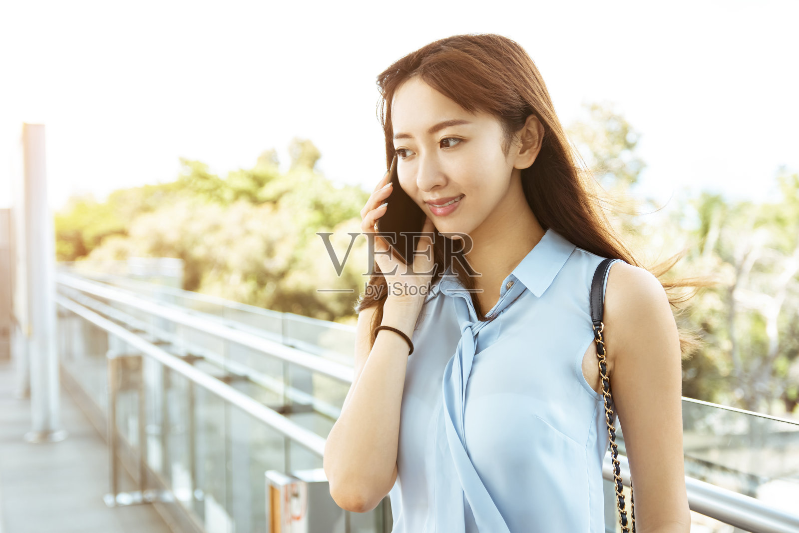 年轻的女商人在火车站打电话照片摄影图片