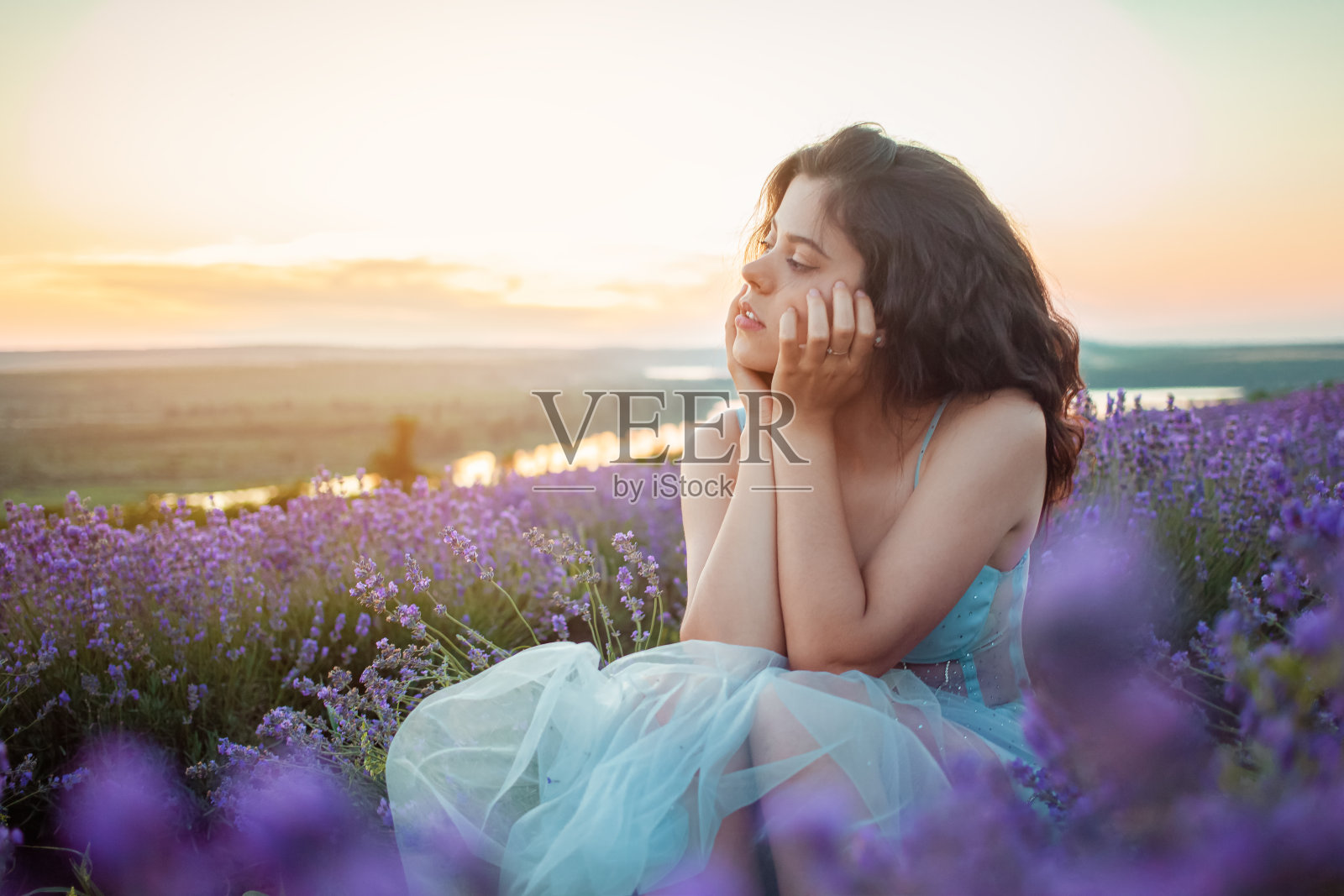 落日和美丽的天空映衬着一个美丽的年轻女孩照片摄影图片