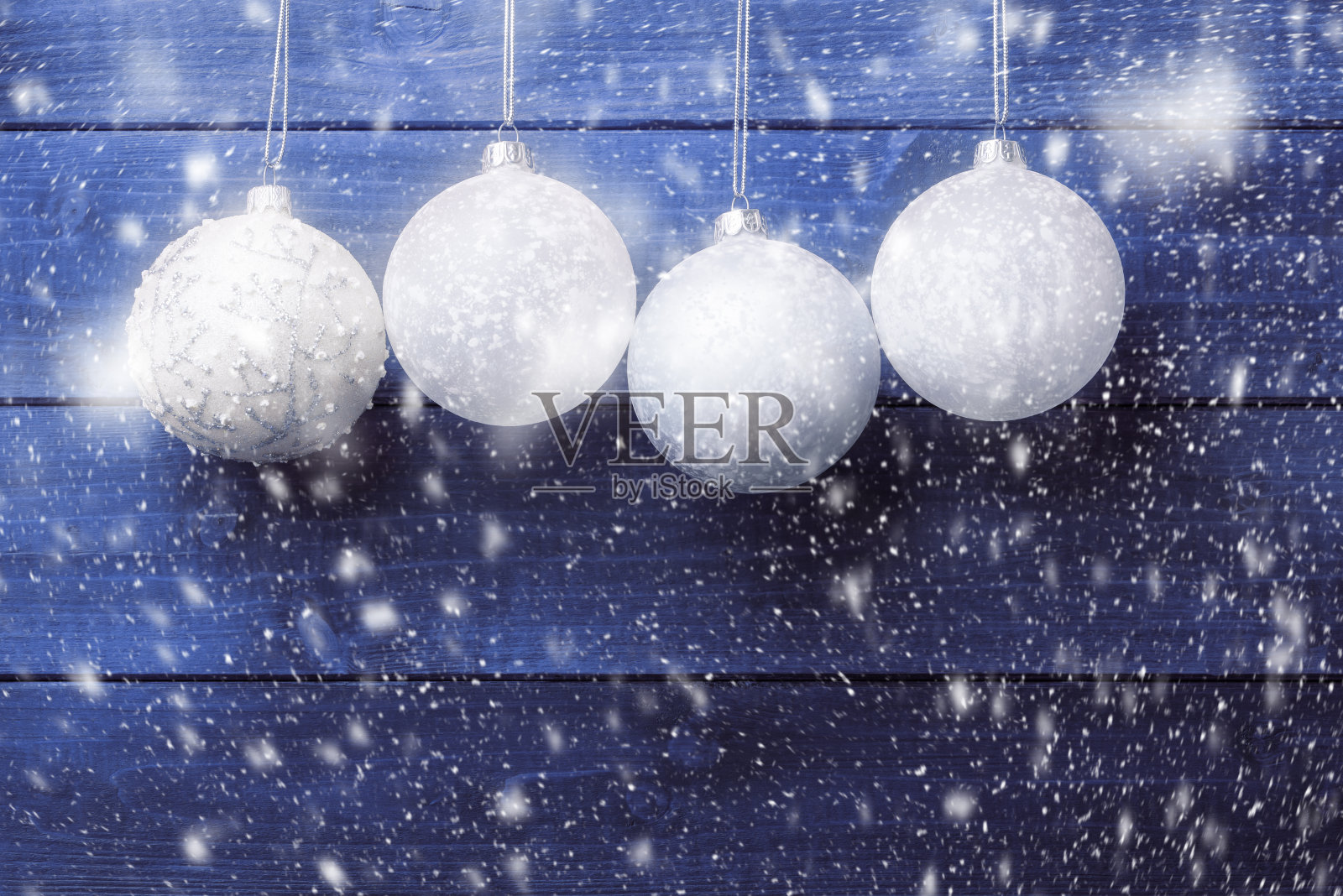 四个圣诞球在蓝色的木制背景。圣诞节和新年的背景照片摄影图片