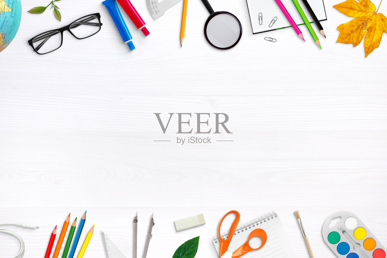 白色的课桌上放着学习用品，中间有空白的空间用来放宣传文字。学校设备组成。俯视图，平放照片摄影图片