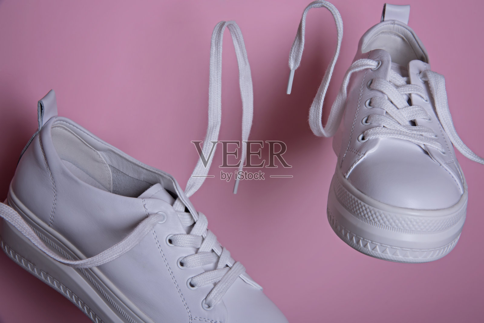 白色的运动鞋在空中飞翔。照片摄影图片