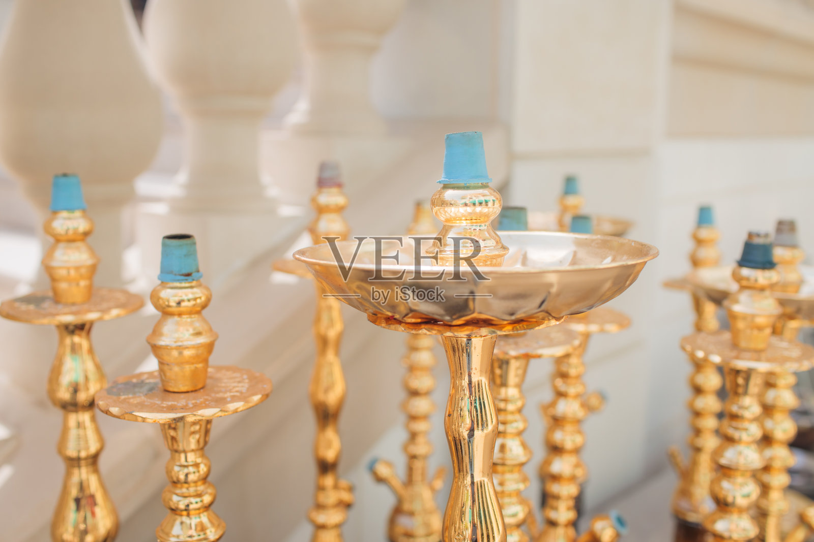 一组现代陶瓷和玻璃水烟或水烟用具在白色木制吧台，海景餐厅。照片摄影图片