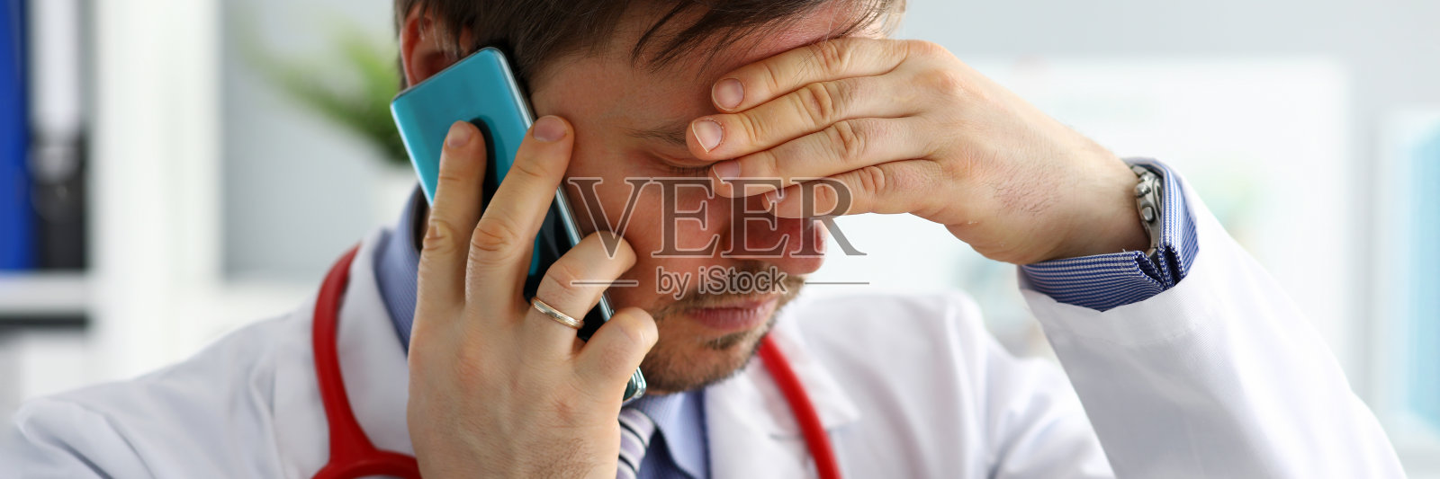 焦虑的医生通过电话听病人的抱怨。照片摄影图片