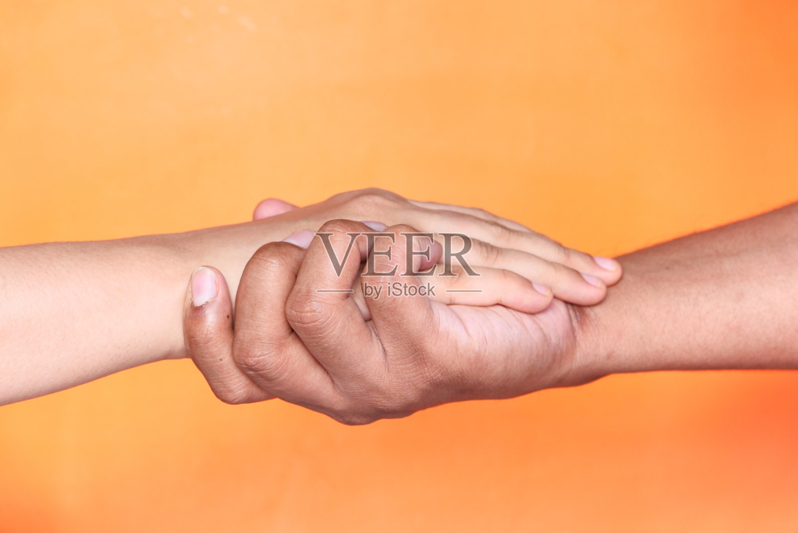 近距离的夫妇牵着手在橙色的背景照片摄影图片