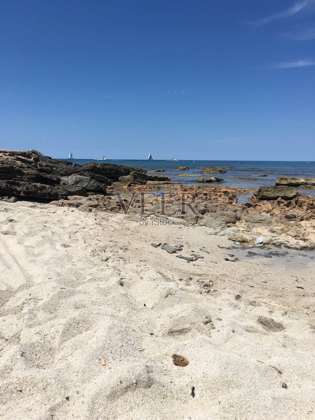 地中海海滩上的白色沙子和岩石照片摄影图片