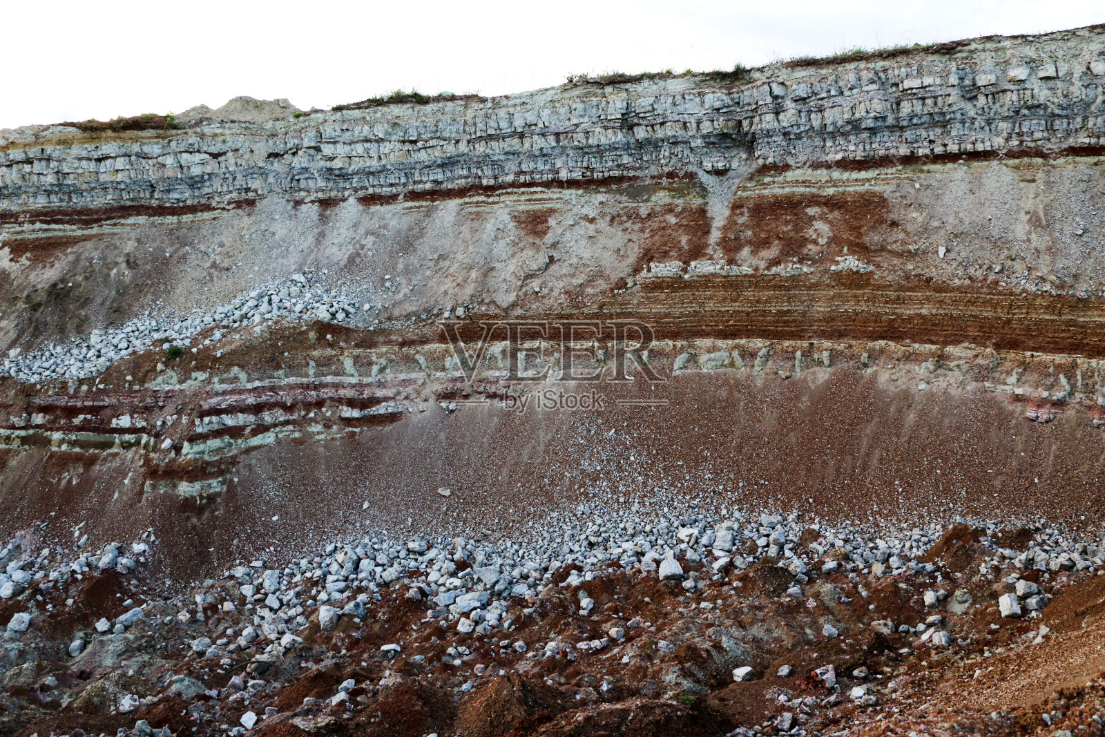 对粘土采石场地下各种粘土层的结构进行了地质研究。彩色的粘土和石头在土地的部分，不同的岩层和土层。照片摄影图片