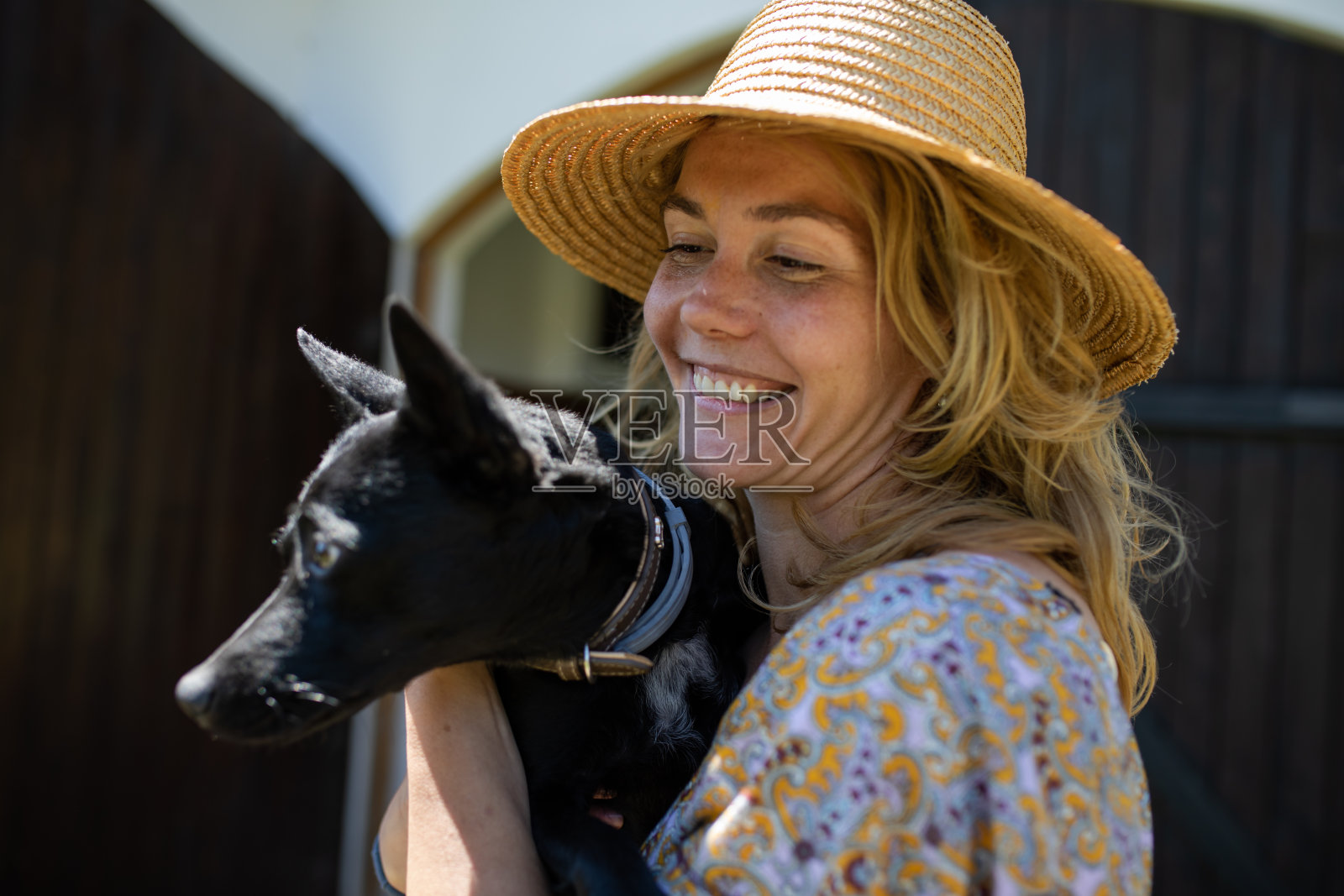 一个乡村女孩微笑着牵着一只狗照片摄影图片