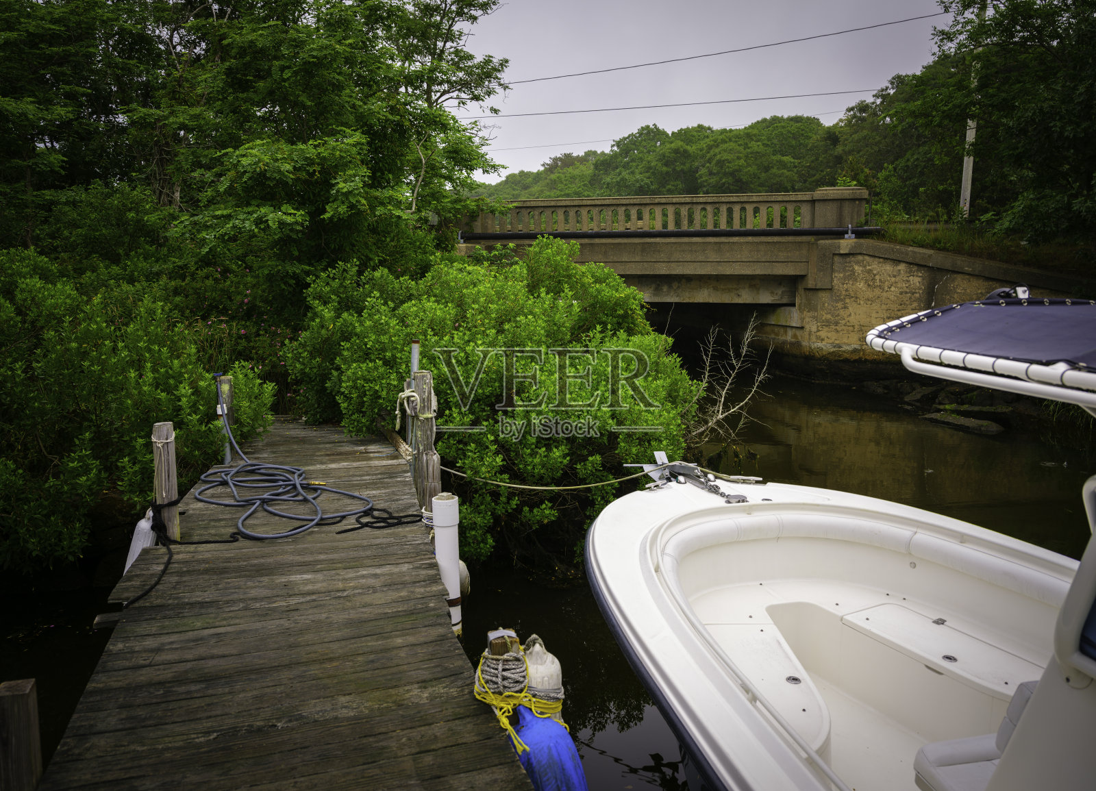 旧桥旁边的码头上疲惫的船的部分视图照片摄影图片