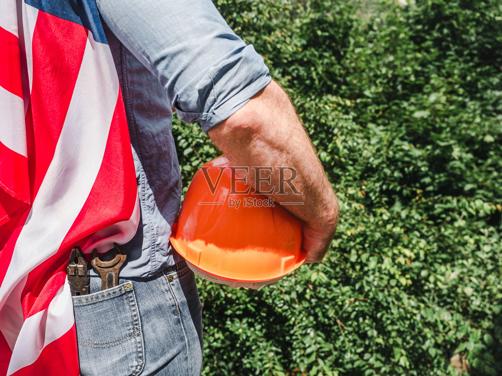 英俊的男人拿着工具，举着美国国旗照片摄影图片