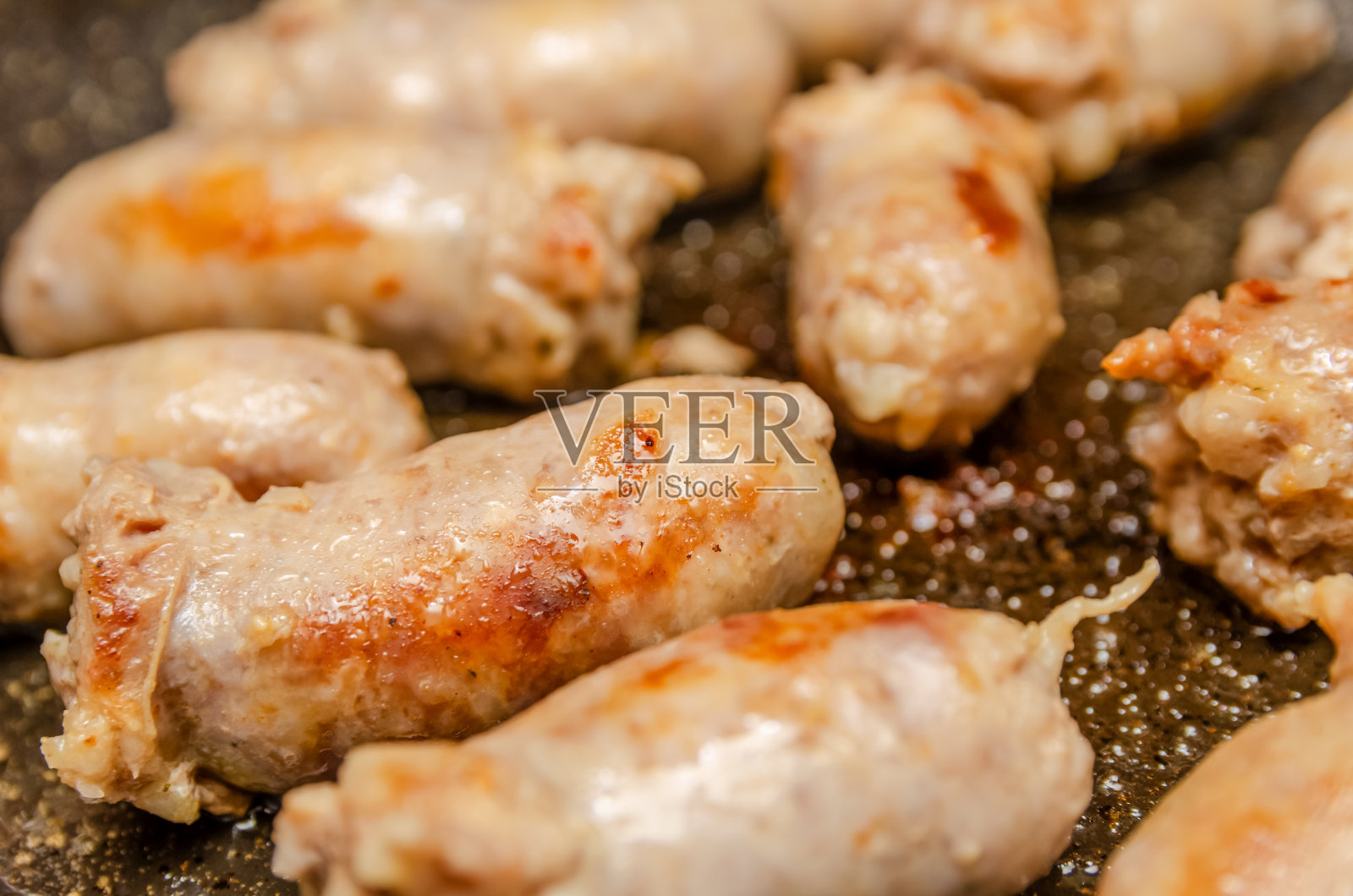 香肠在煎锅里炸熟照片摄影图片