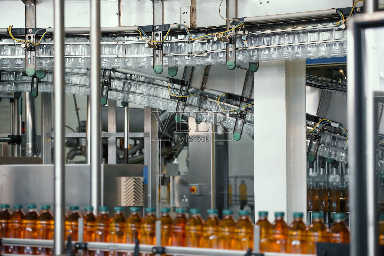 在现代饮料厂的输送线上或皮带上装有果汁的塑料瓶照片摄影图片