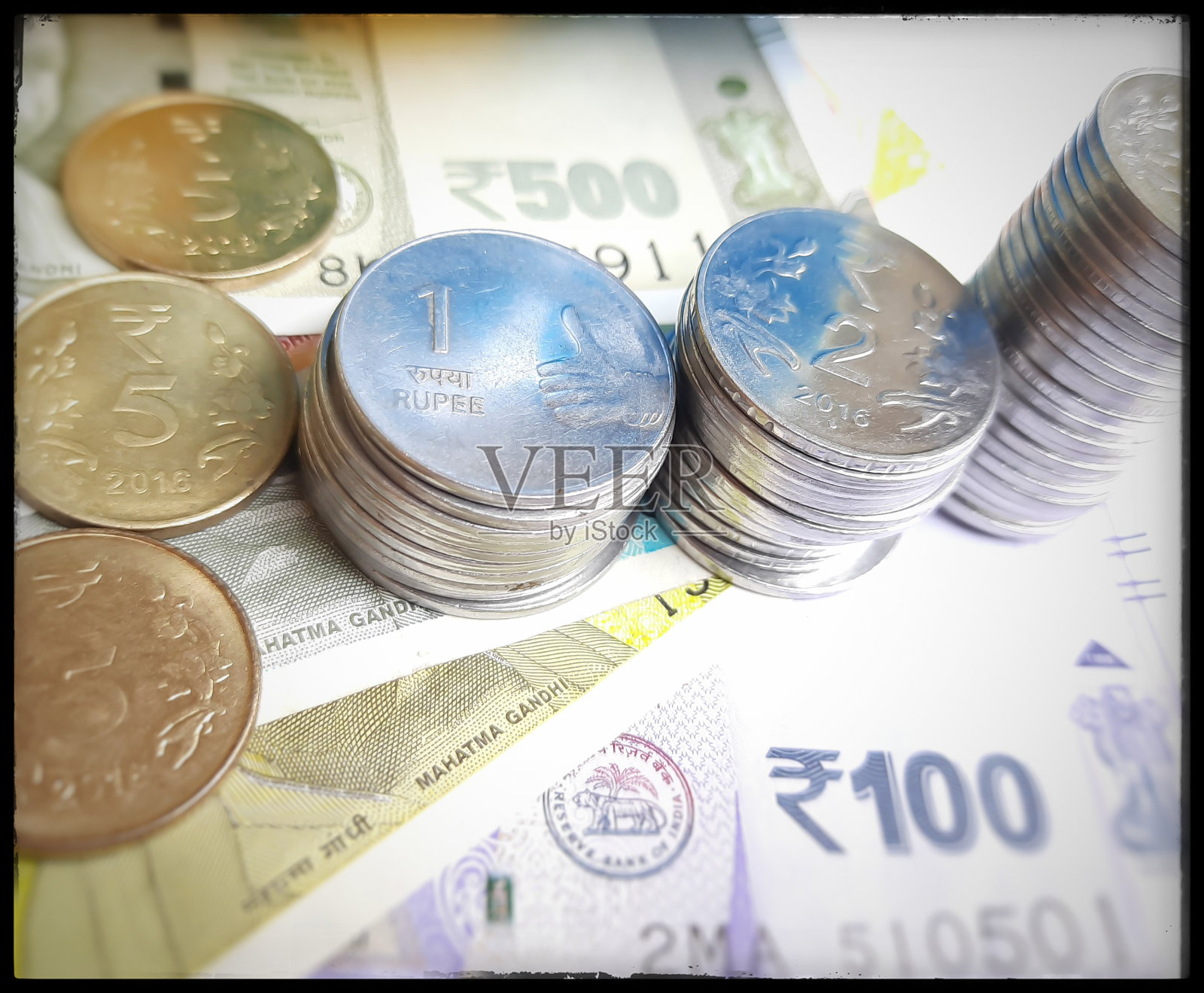 印度的新卢比货币与所有的卢比硬币随机分布，就像在白纸背景下增长储蓄一样照片摄影图片