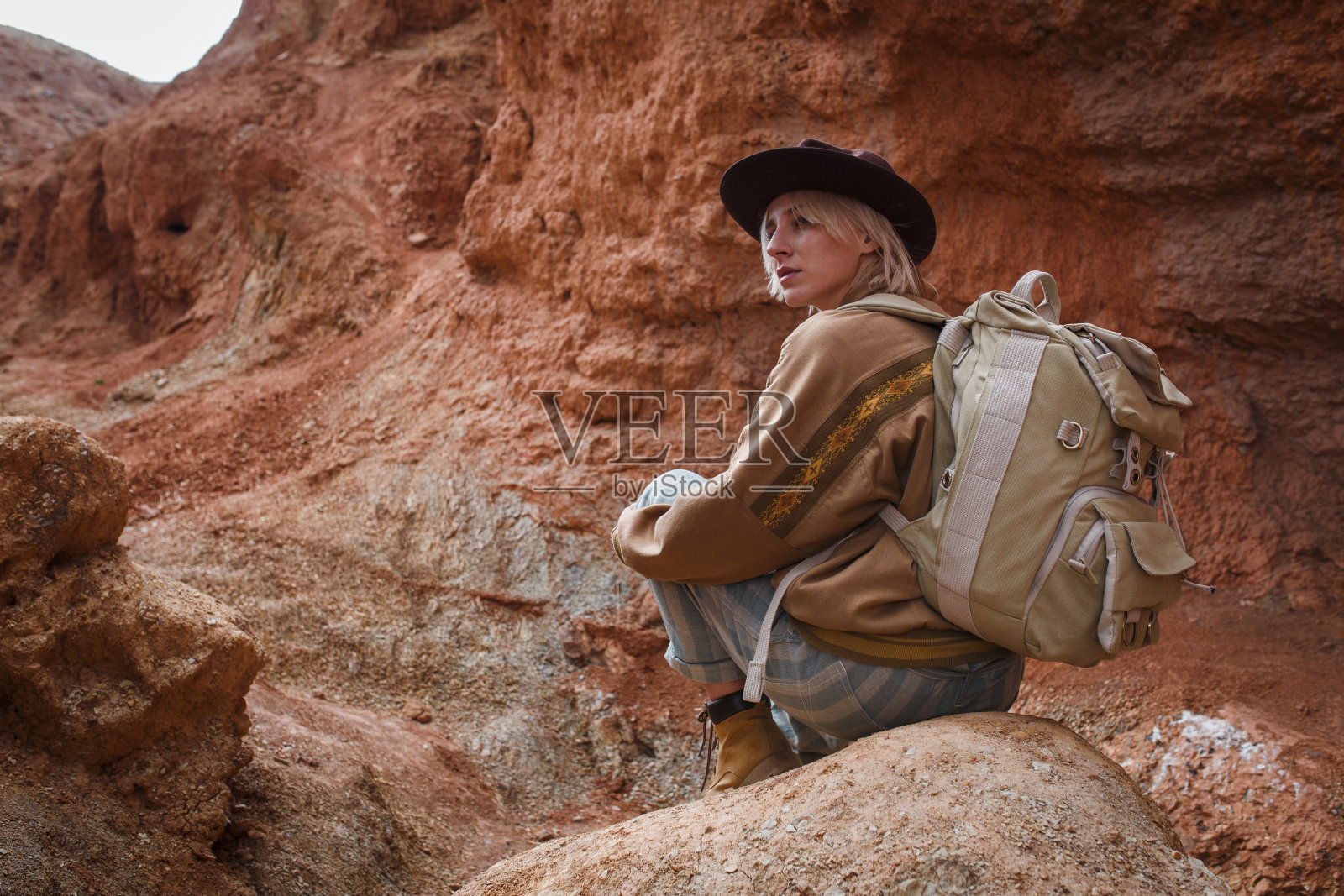美丽的年轻女孩在野兔，帽子和背包旅行在野外的沙子照片摄影图片