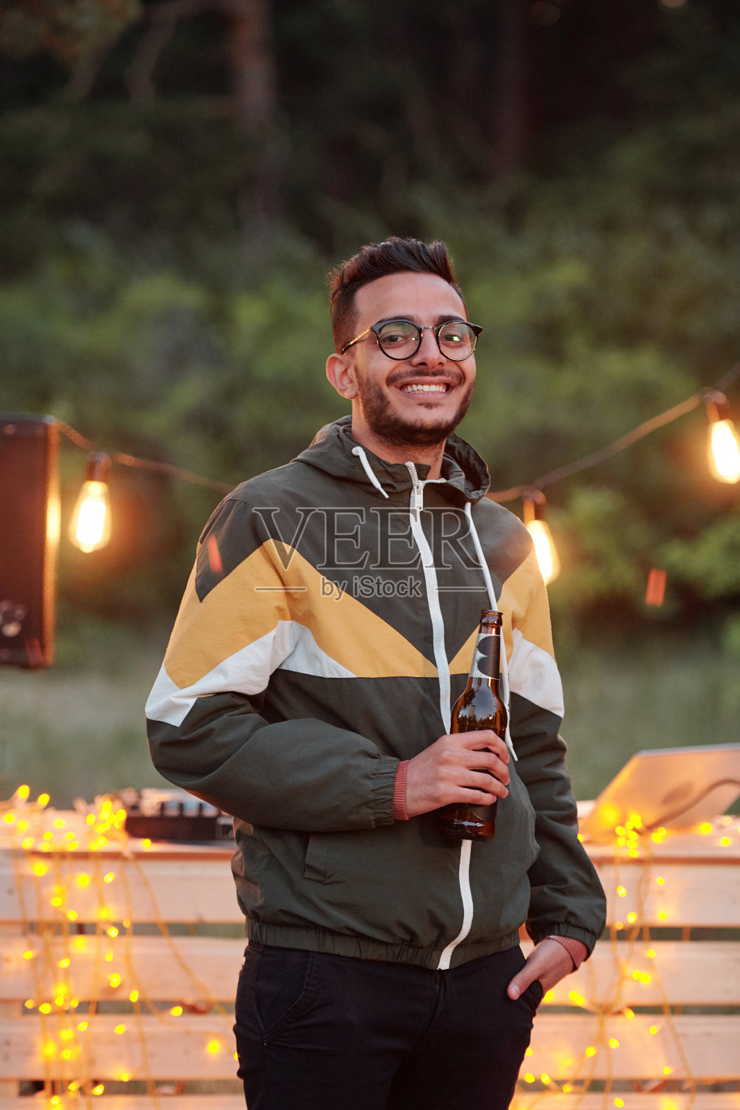 年轻的混血儿在灯光下喝啤酒照片摄影图片