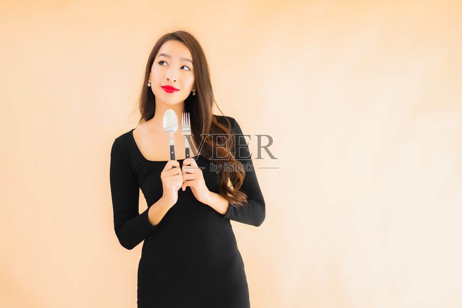 肖像美丽的年轻亚洲妇女与匙和叉照片摄影图片