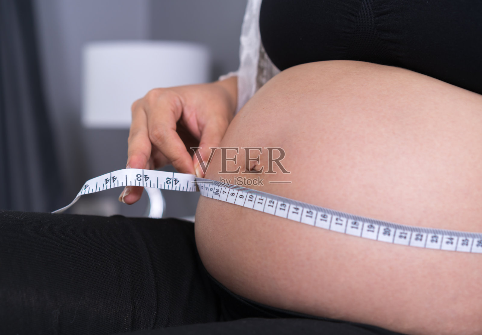 孕妇用卷尺量肚子照片摄影图片