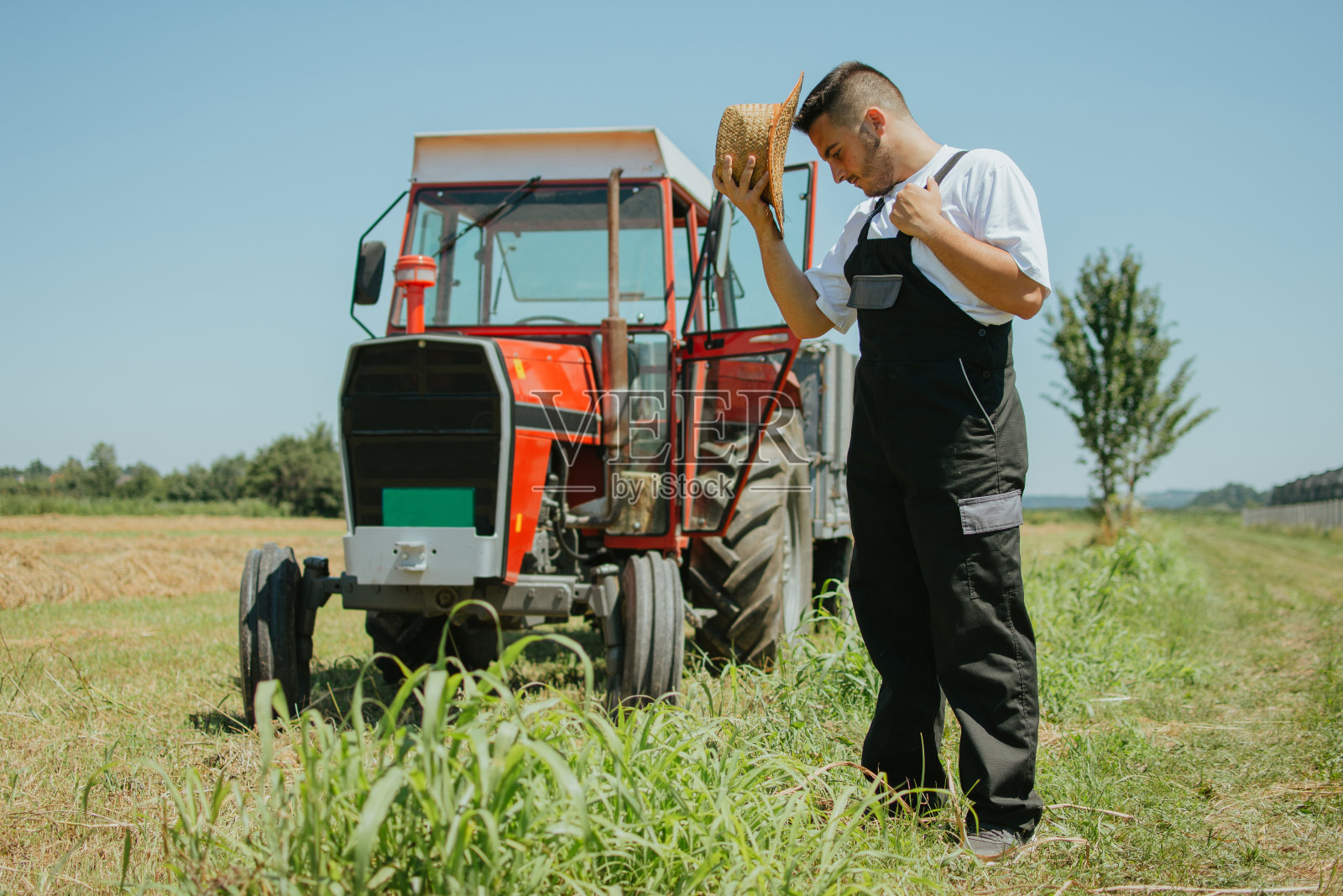 农夫在他的拖拉机前照片摄影图片