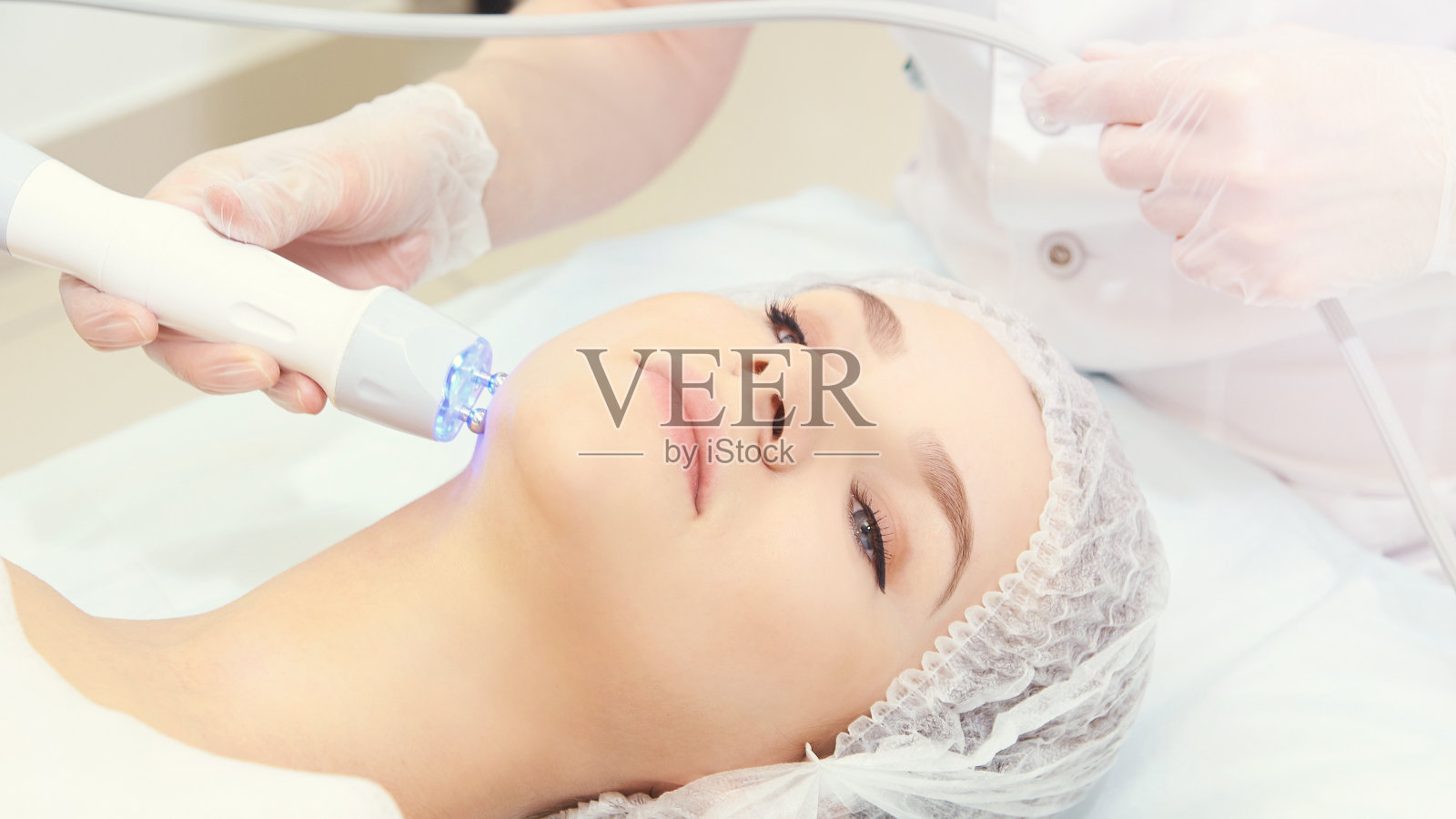 皮肤护理面部治疗。医疗水疗anto皱纹程序。女人面临复兴。漂亮的女孩。射频美容设备。下巴和脖子照片摄影图片