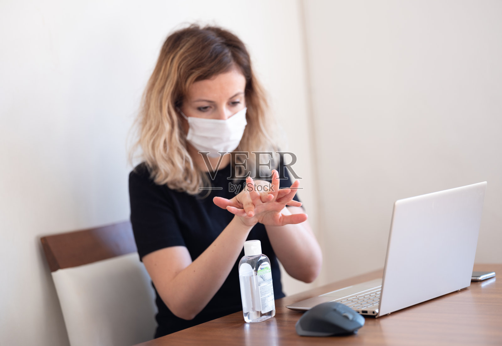 年轻女性用抗菌洁面乳洗手以保护自己免受Covid-19感染照片摄影图片