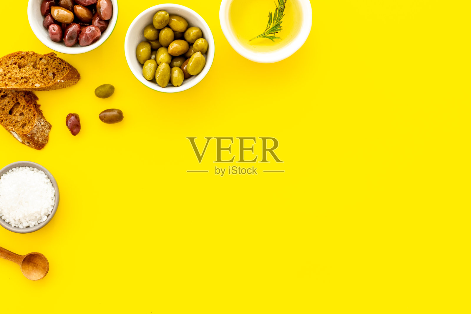 俯视图橄榄，橄榄油，面包在黄色桌子俯视图拷贝空间照片摄影图片