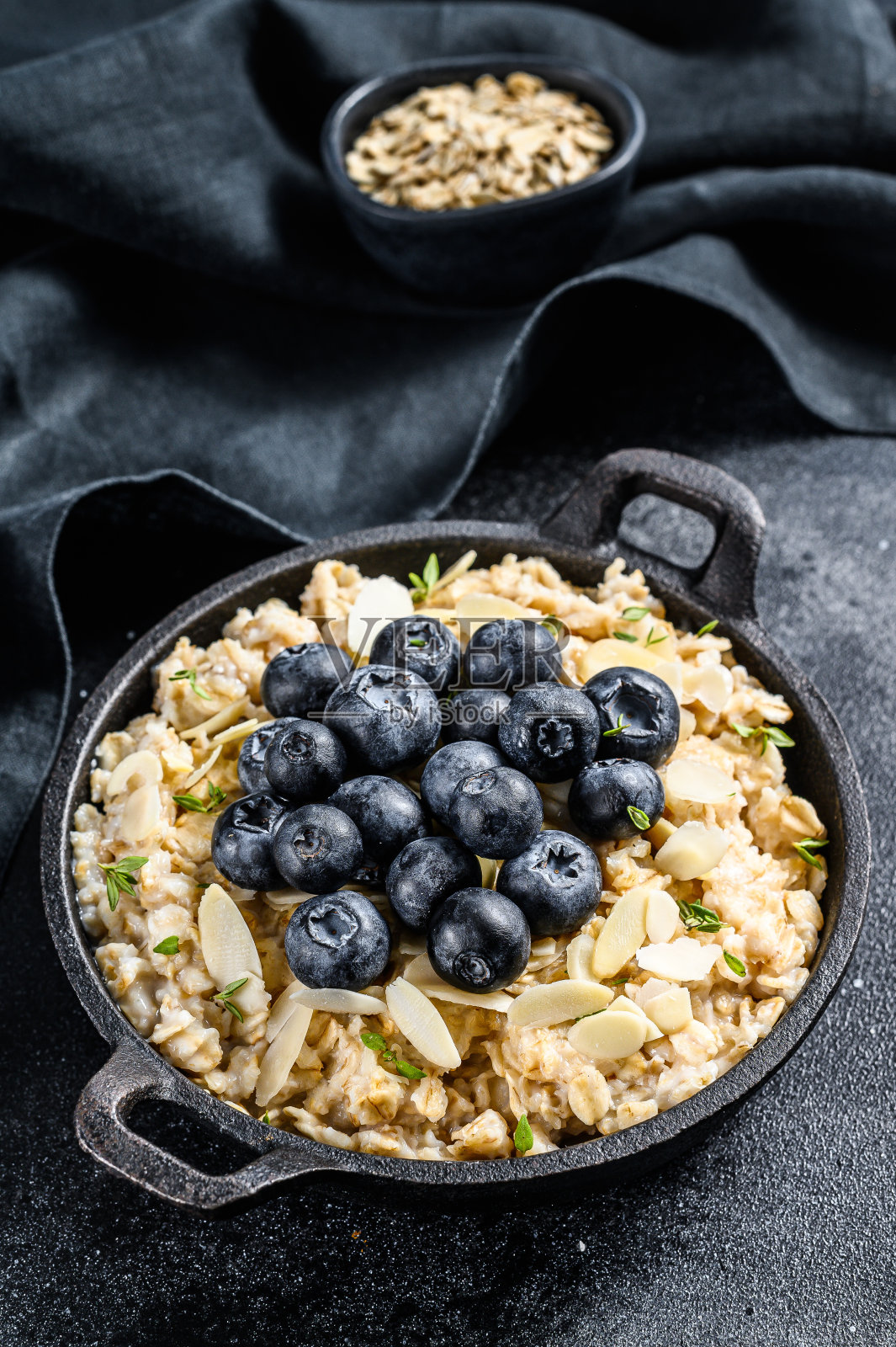 蓝莓杏仁燕麦粥。黑色背景。俯视图照片摄影图片