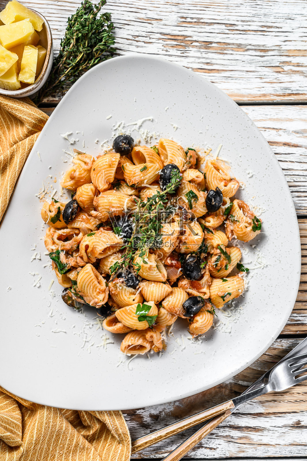 用蕃茄、橄榄、刺山柑、凤尾鱼拌意大利面。白色背景。俯视图照片摄影图片