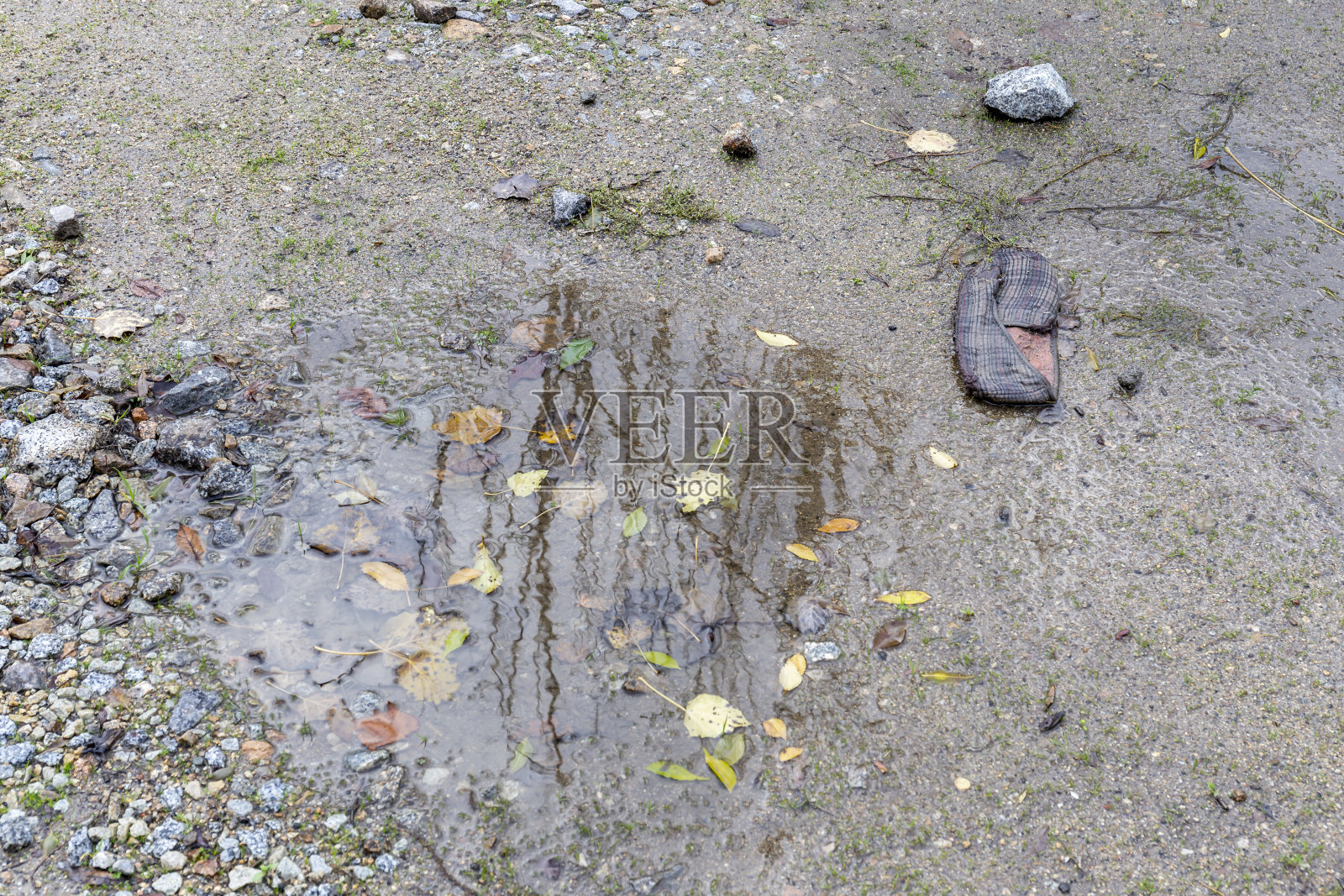 废弃的鞋子旁边的水泥泞的地面上照片摄影图片