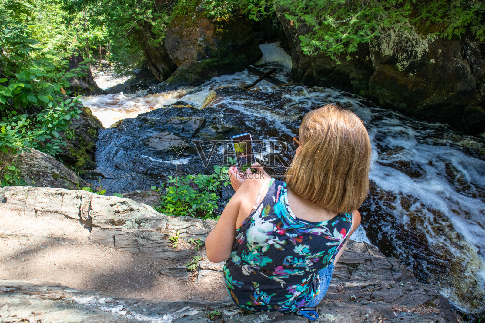 一位女士正在用智能手机拍威斯康星河的照片照片摄影图片