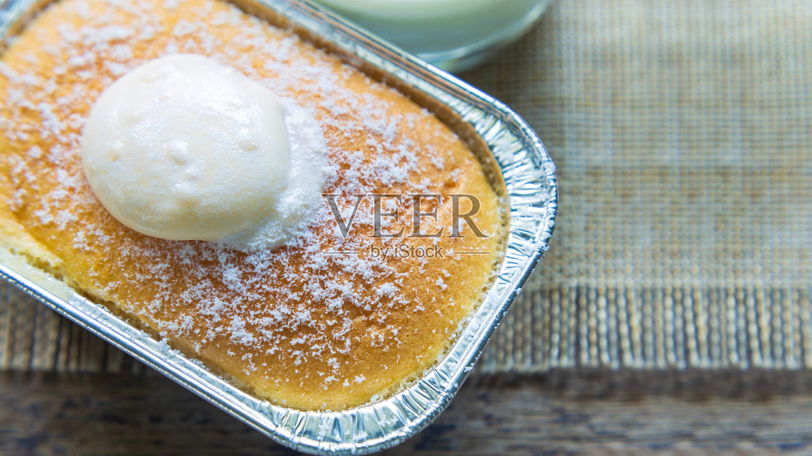 高角度的观点近距离观察一杯北海道牛奶面包顶部奶油在木桌上，一杯牛奶在早上。照片摄影图片