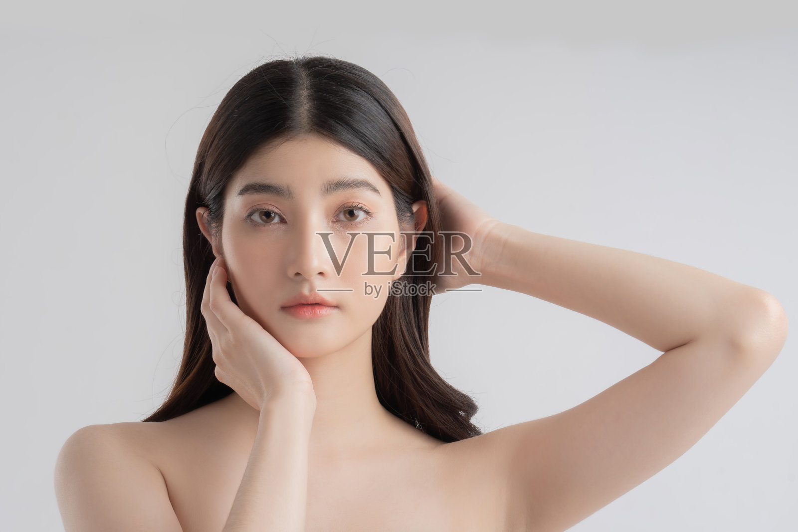 美丽的亚洲女人有一个美丽的脸她拿着她的头发和头。照片摄影图片