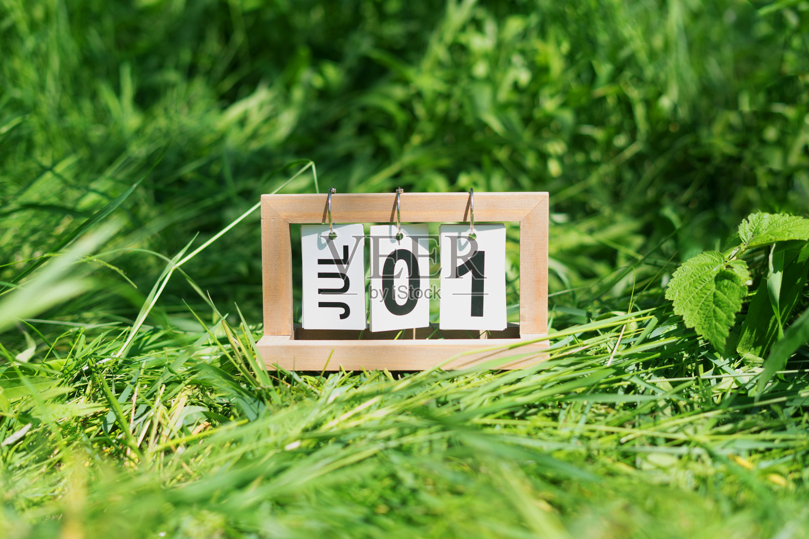 折叠日历与日期7月1日在草地上。照片摄影图片